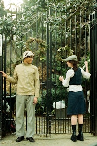 a man and a woman standing in front of a gate