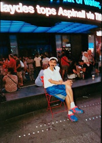 a man sitting in a chair in front of a sign